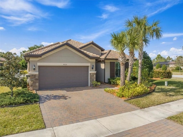 mediterranean / spanish home with a garage and a front yard