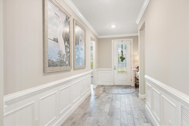 foyer with light wood-type flooring and ornamental molding