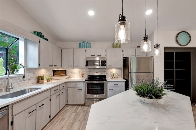 kitchen with stainless steel appliances, decorative backsplash, sink, hanging light fixtures, and vaulted ceiling