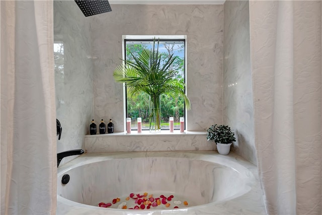 bathroom featuring a bathing tub and plenty of natural light