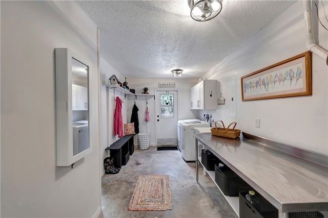 interior space with a textured ceiling, cabinets, and washer and dryer