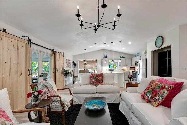 living room with lofted ceiling, a barn door, and an inviting chandelier