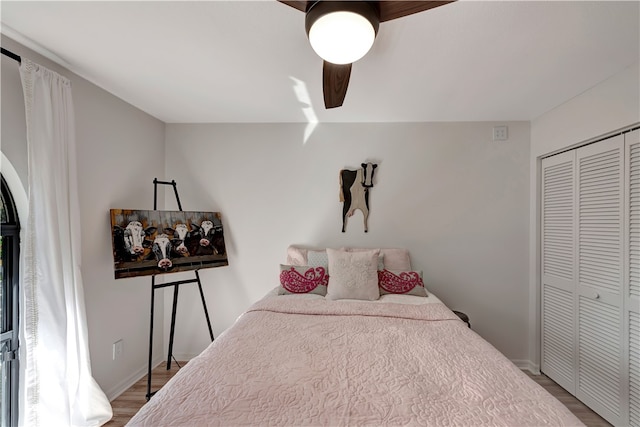 bedroom with ceiling fan, a closet, and wood-type flooring