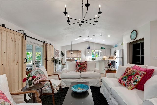 living room featuring a barn door, vaulted ceiling, and a notable chandelier