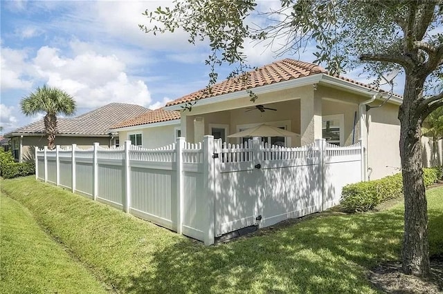 rear view of property with a yard and ceiling fan