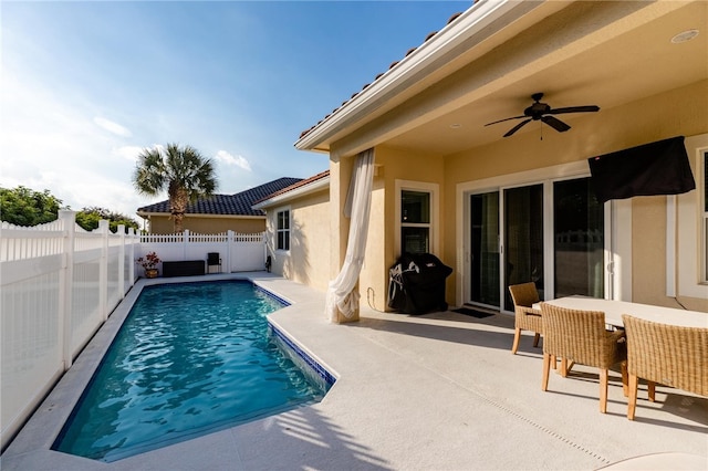 view of pool with a grill, ceiling fan, and a patio area