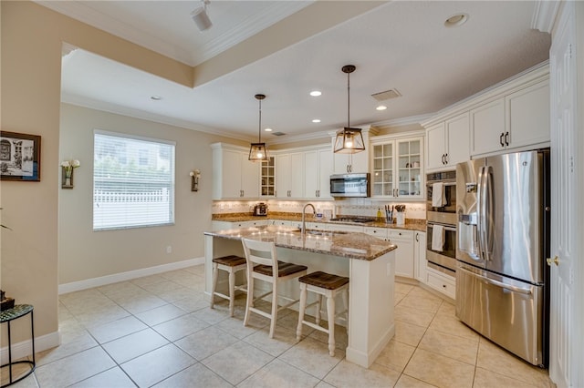 kitchen featuring white cabinetry, stainless steel appliances, crown molding, pendant lighting, and a kitchen island with sink