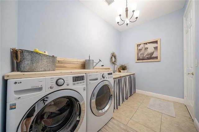 washroom with washing machine and dryer, sink, light tile patterned floors, and a notable chandelier