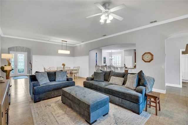 tiled living room featuring ceiling fan and ornamental molding