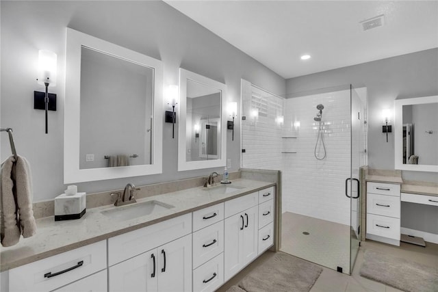 bathroom with tile patterned flooring, vanity, and walk in shower