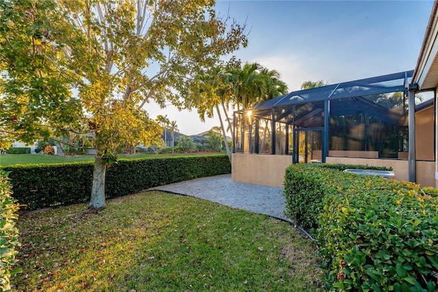 view of yard featuring glass enclosure and a patio area