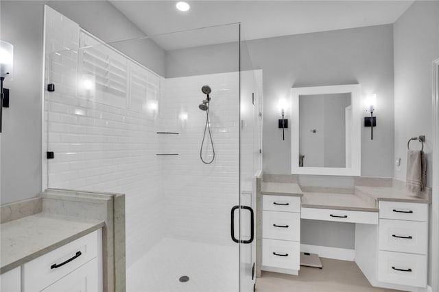 bathroom with vanity and a shower with door