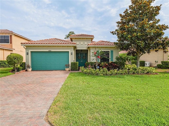 mediterranean / spanish home with a garage and a front lawn