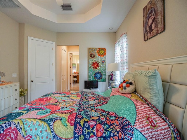 bedroom with ceiling fan, a raised ceiling, and a closet