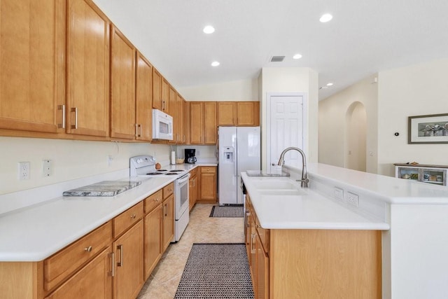 kitchen featuring sink, white appliances, a kitchen island with sink, and light tile patterned floors