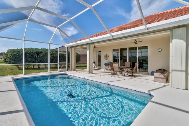 view of swimming pool featuring ceiling fan, a patio area, and glass enclosure