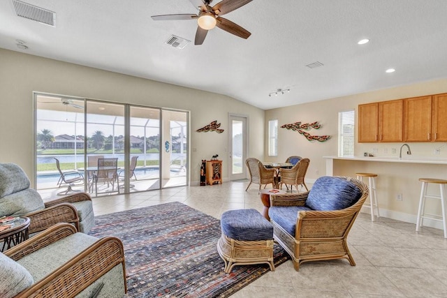 tiled living room featuring ceiling fan and sink