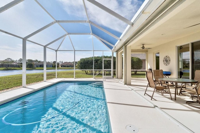 view of pool featuring a lanai, ceiling fan, a water view, and a patio