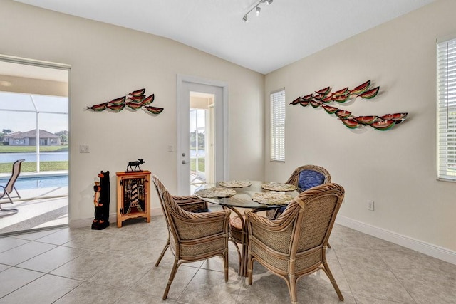 dining space featuring light tile patterned floors and vaulted ceiling