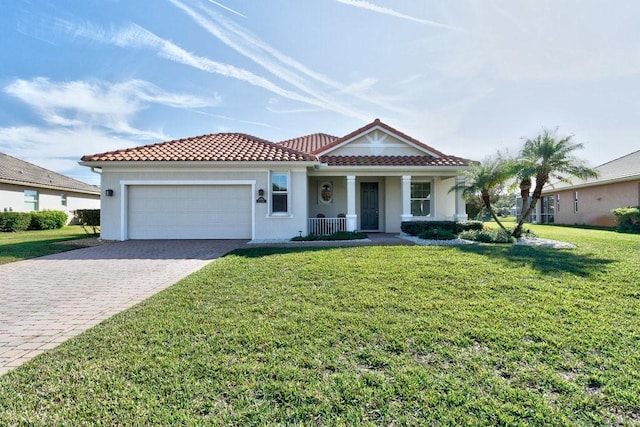 mediterranean / spanish home featuring a front yard, a porch, and a garage