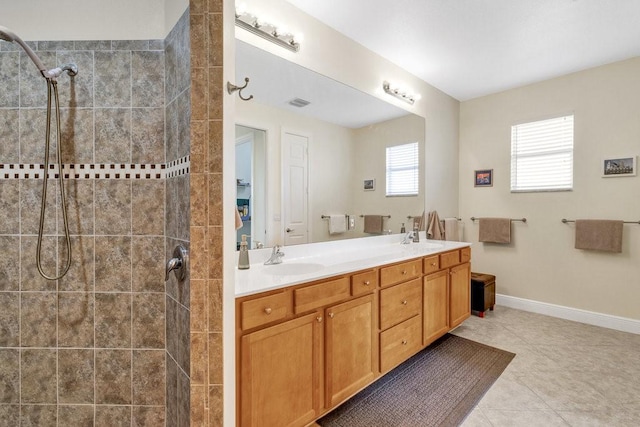 bathroom featuring a tile shower, tile patterned flooring, and vanity