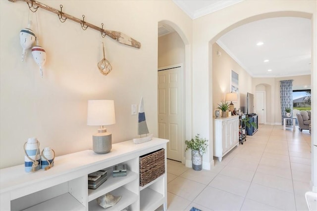 hallway featuring light tile patterned floors and ornamental molding