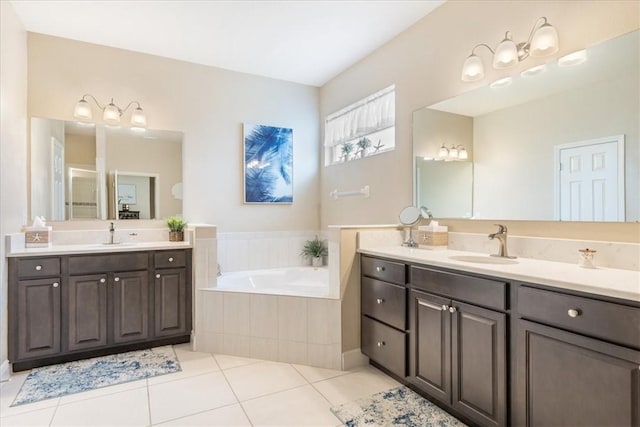 bathroom with tile patterned floors, vanity, and tiled bath