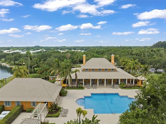 view of swimming pool featuring a water view and a patio area