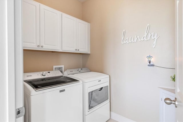 washroom featuring cabinets and separate washer and dryer