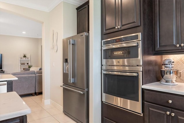 kitchen with decorative backsplash, ornamental molding, dark brown cabinets, light tile patterned flooring, and stainless steel appliances