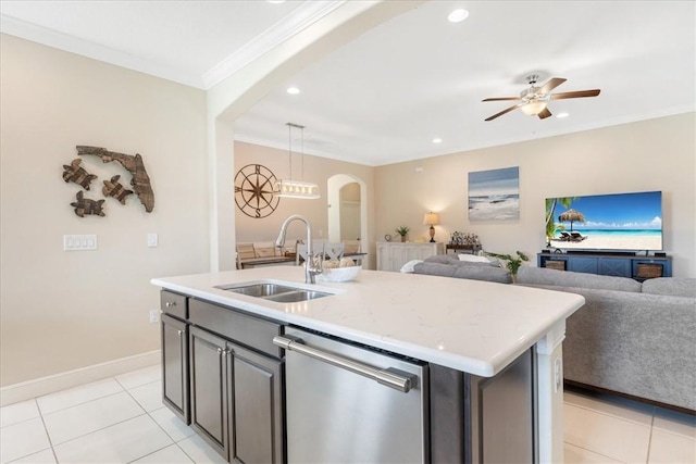 kitchen featuring ceiling fan, sink, stainless steel dishwasher, decorative light fixtures, and a center island with sink