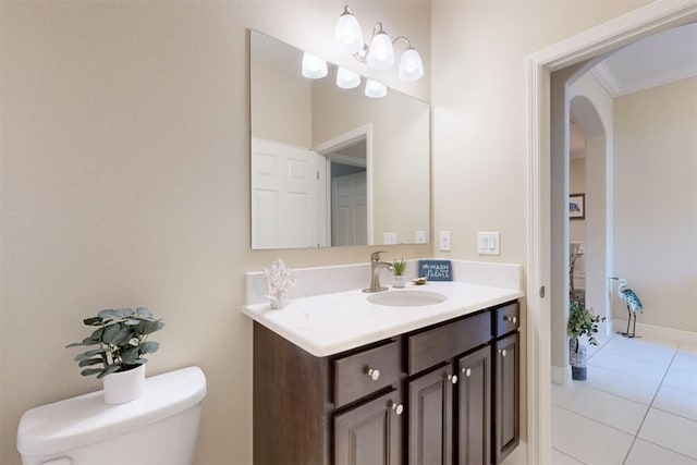 bathroom with tile patterned flooring, vanity, toilet, and ornamental molding