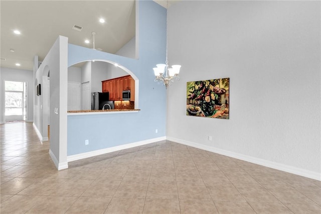 interior space with recessed lighting, a towering ceiling, light tile patterned floors, and a notable chandelier