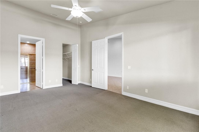 unfurnished bedroom with baseboards, visible vents, and dark colored carpet
