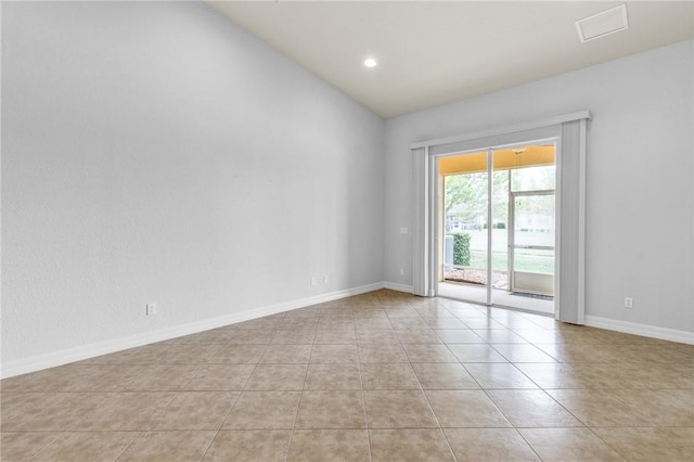 empty room with baseboards, vaulted ceiling, recessed lighting, and light tile patterned flooring