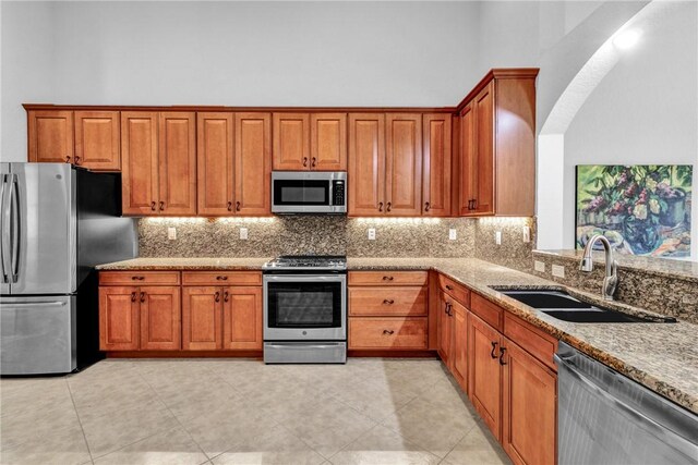 kitchen featuring brown cabinets, appliances with stainless steel finishes, and a sink