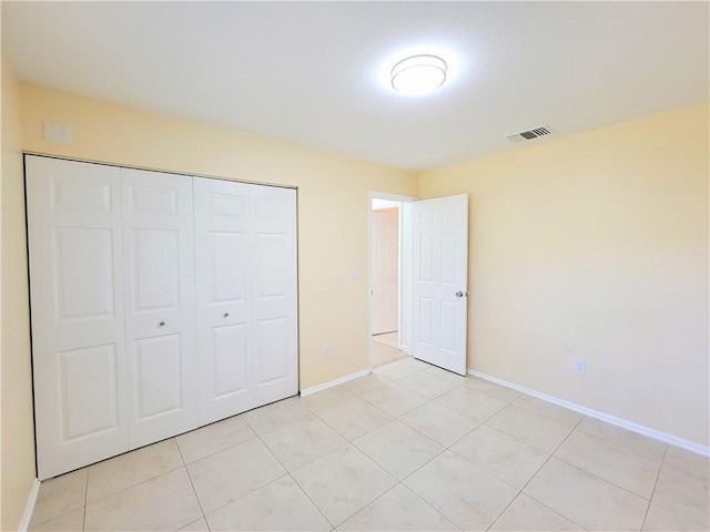 unfurnished bedroom featuring light tile patterned flooring and a closet