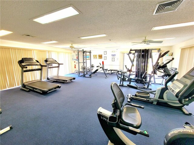 exercise room with ceiling fan and a textured ceiling