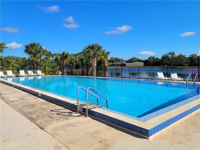 view of swimming pool featuring a water view and a patio