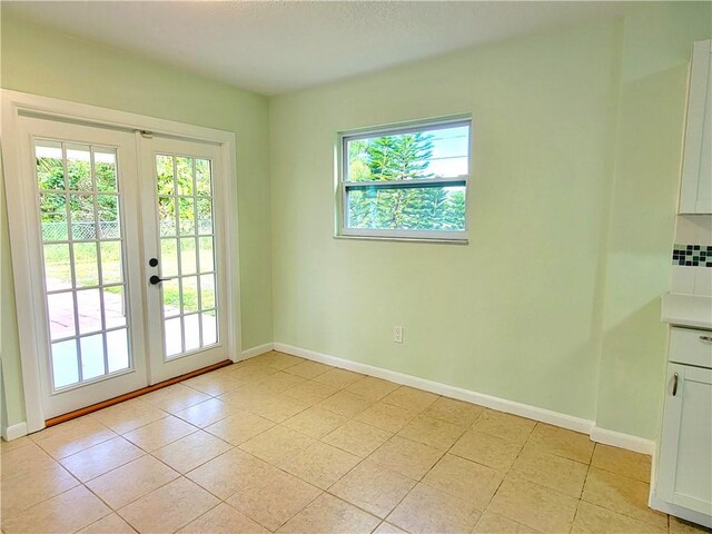 entryway featuring light tile patterned floors and french doors