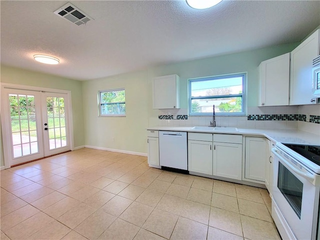 kitchen with sink, white cabinetry, white appliances, and light tile patterned floors