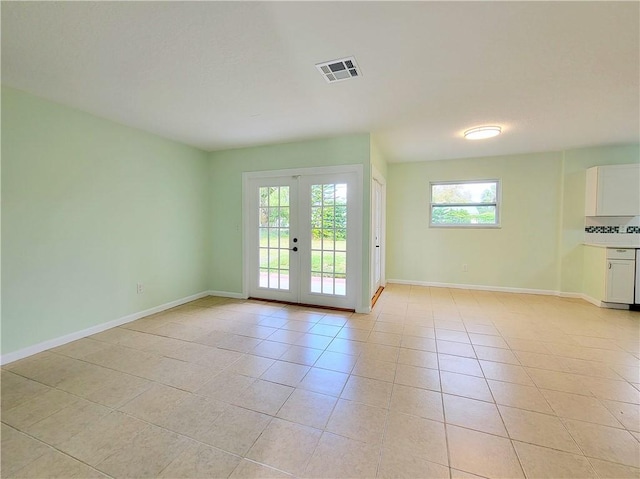 doorway to outside with light tile patterned floors and french doors