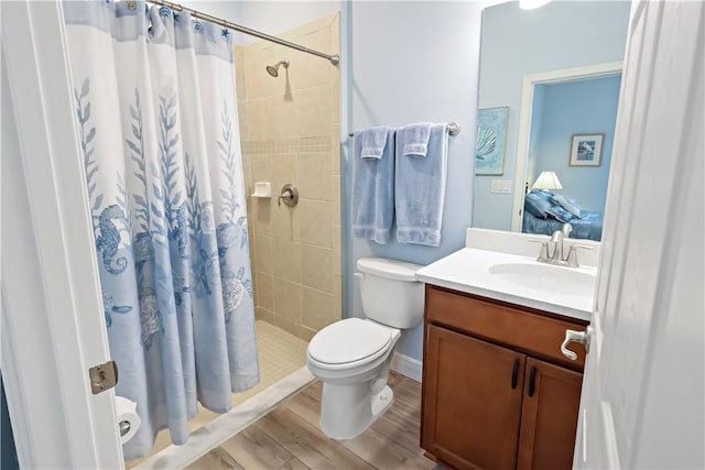 bathroom featuring hardwood / wood-style flooring, vanity, toilet, and walk in shower
