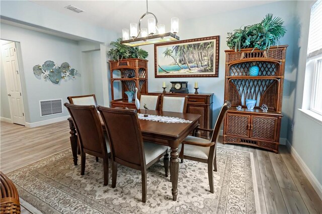 dining room featuring light hardwood / wood-style flooring and a notable chandelier