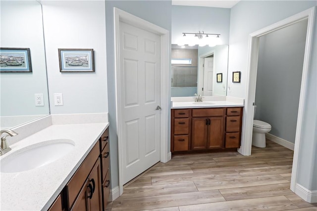 bathroom with vanity, toilet, and wood-type flooring