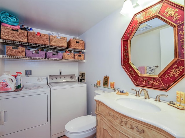 bathroom with vanity, washing machine and dryer, and toilet