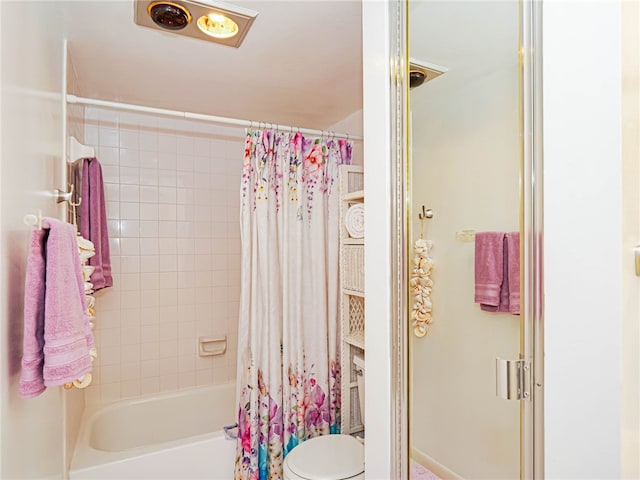 bathroom featuring shower / bath combination with curtain and toilet