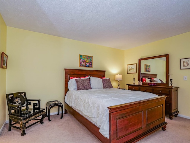 bedroom featuring a textured ceiling and light carpet