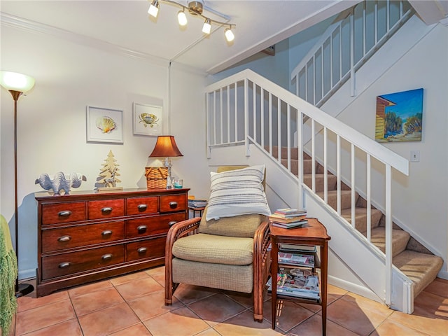 living area with crown molding and light tile patterned flooring