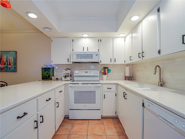 kitchen with white appliances, crown molding, sink, light tile patterned floors, and white cabinetry